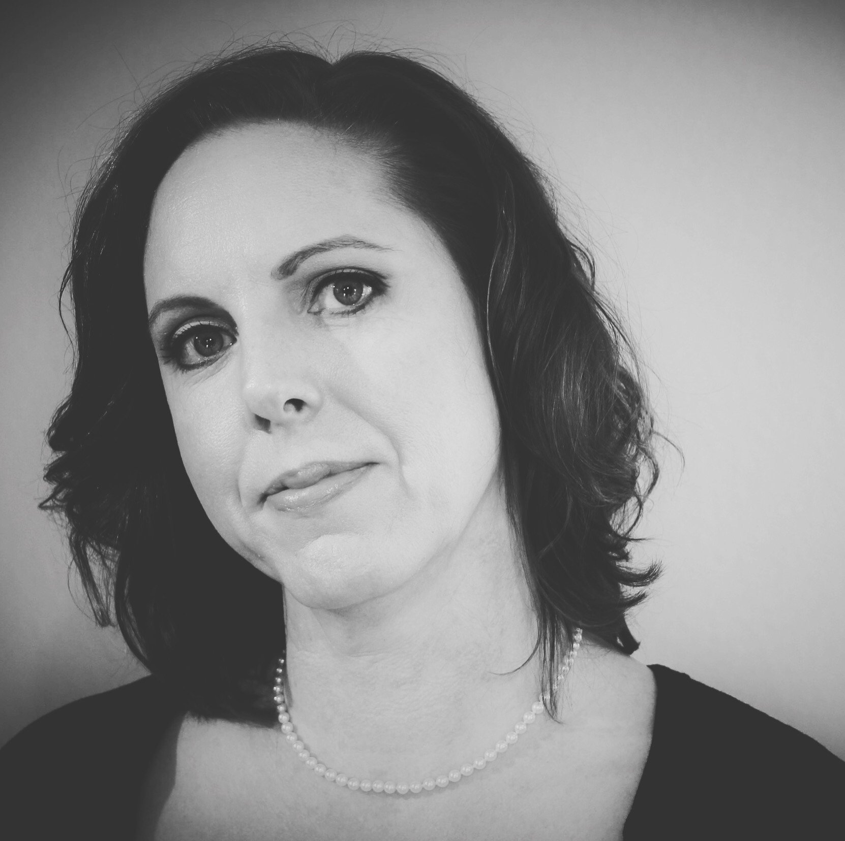 Black-and-white portrait of Wendy Lynn wearing a pearl necklace and dark top